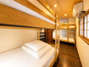a room with two bunk beds and a window at Osaka Guesthouse Sakura in Osaka