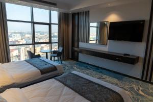 a hotel room with a large bed and a flat screen tv at فندق ديماس DEMAS Hotel in Khamis Mushayt