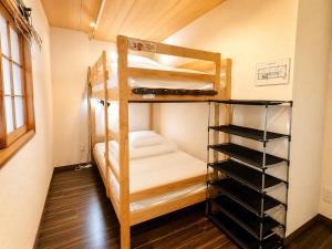 a bunk bed in a room with a ladder at Osaka Guesthouse Sakura in Osaka +13 photos