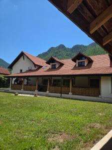 a house with a roof with mountains in the background at Cuib de Munte in Brezoi
