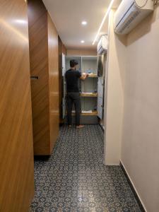 a man standing in a refrigerator in a room at Nathan's Residency in Tiruchirappalli