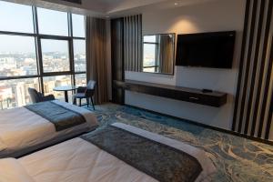 a hotel room with two beds and a flat screen tv at فندق ديماس DEMAS Hotel in Khamis Mushayt