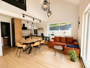 a living room with a couch and a table and chairs at Skośne Domki 2 in Chmielno