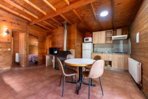 a kitchen with a table and chairs in a room at Cabañas Cortijo el Helao in Pozo Alcón