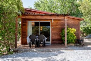 a wooden shed with two chairs and a table at Cabañas Cortijo el Helao in Pozo Alcón