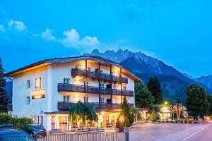 a hotel building with a mountain in the background at Chasca Living in Dobbiaco