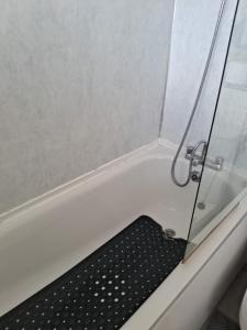 a bathtub with a black bath mat in it at 4 mereside walk in Manchester