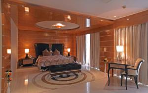 a bedroom with a bed and a table and a desk at Royal Orchid Central Kireeti Hampi in Hampi