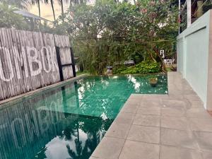 a swimming pool with green water and a wooden fence at Lombok House Mentigi in Teluknarat +9 photos