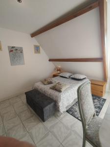 a bedroom with a bed and a chair at L'épi de blé in Saint-Astier