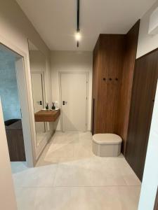 a bathroom with a toilet and a wooden cabinet at MJ Apartments in Łomża