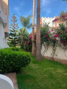 a yard with palm trees and bushes and flowers at Chic Villa - Pool - Wi-Fi -Parking - 3 Bedrooms in Sidi Bouzid