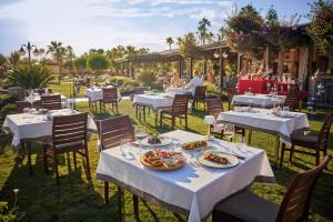 a restaurant with white tables and chairs with food on them at TUI MAGIC LIFE Belek in Belek