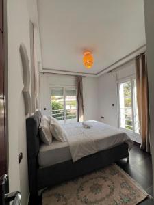 a bedroom with a bed and two windows at Chic Villa - Pool - Wi-Fi -Parking - 3 Bedrooms in Sidi Bouzid +20 photos