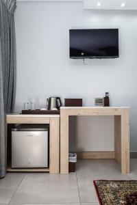 a living room with a table with a flat screen tv at Lasaro Guest Lodge in Bethlehem