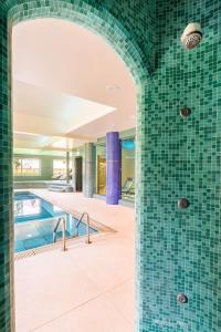 a swimming pool with green tiles on the wall at Chasca Living in Dobbiaco