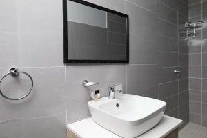 a bathroom with a white sink and a mirror at Lasaro Guest Lodge in Bethlehem