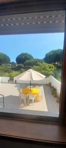 a yellow table and chairs and an umbrella on a patio at Cantinho da Mariana in Moledo