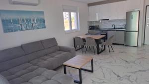 a living room with a couch and a table and a kitchen at Mima apartments in Povljana