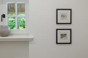 a window in a white room with a vase on a shelf at Sommerhaus in Keitum