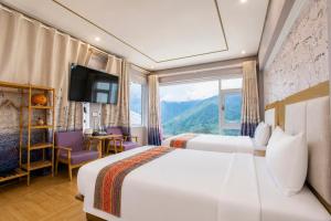 a hotel room with a large bed and a window at Terravia Hotel Sapa Moutain View in Sapa