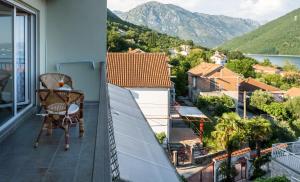 a balcony with a chair and a view of the mountains at Seaside Village in Kamenari