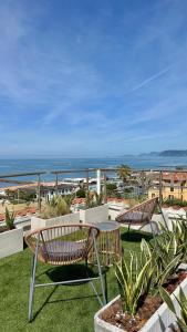 a patio with two benches and a view of the ocean at Hotel Tirreno in Marina di Massa