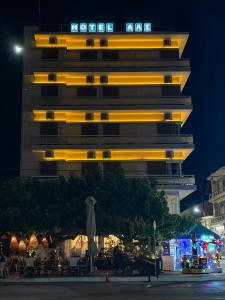 a tall building with yellow lights on it at night at Hotel ALS KARYSTOS in Karistos