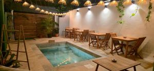 a patio with a swimming pool and tables and chairs at La villa du jardin in Saint-Denis