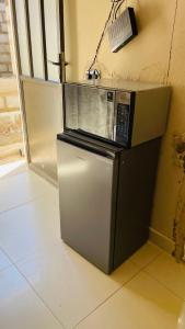 a microwave sitting on top of a refrigerator at Umthombo guest house in Mbabane