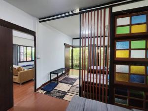 a living room with a door open to a room with a couch at Villa Him Doi in Ban Mae Rim Nua