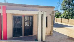 a small building with a gate and a door at Umthombo guest house in Mbabane