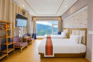 a hotel room with two beds and a large window at Terravia Hotel Sapa Moutain View in Sapa