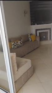 a living room with a brown couch and a fireplace at Garden Beach 2 in Casablanca +1 photo
