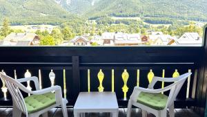 two chairs and a table on a balcony with a view at Appartementhaus Huber in Abersee