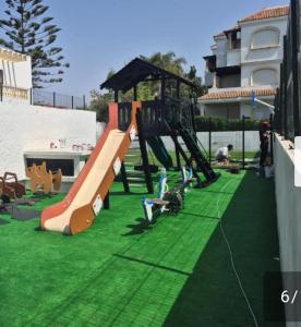 a playground with a slide on the grass at Garden Beach 2 in Casablanca