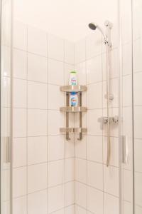 a shower with a bottle of hand soap on a shelf at Authentic Klauzal Apartment in Budapest