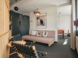 a living room with a couch and chairs at Oru Hub Hotel Tallinn - Handwritten Collection in Tallinn