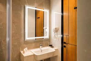 a bathroom with a sink and a mirror at Central Residence by Paramount Hospitality in Karachi +35 photos