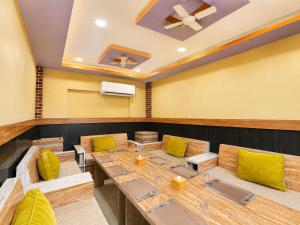 a dining room with wooden tables and yellow cushions at Brichyalaya Kohalpur in Kohalpur