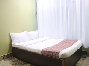 a bed sitting in a room with a window at Brichyalaya Kohalpur in Kohalpur