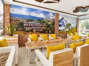 a restaurant with a mountain mural on the wall at Brichyalaya Kohalpur in Kohalpur
