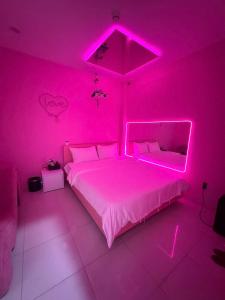 a pink bedroom with a bed with a pink lighting at Đào Hoa Love Hotel Đà Nẵng in Danang