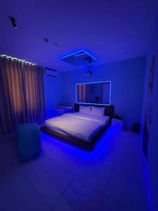 a bedroom with a bed with a blue lighting at Đào Hoa Love Hotel Đà Nẵng in Danang