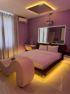 a bedroom with a large bed with a lighted headboard at Đào Hoa Love Hotel Đà Nẵng in Danang