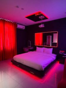 a bedroom with a large bed with red lights at Đào Hoa Love Hotel Đà Nẵng in Danang