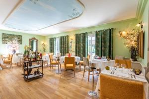a dining room with tables and chairs and green walls at Logis Hôtel La Bastide De Grignan & Restaurant La Chênaie in Grignan