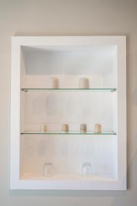 a white shelf with glass bowls on it at Elia Suites in Falasarna +84 photos