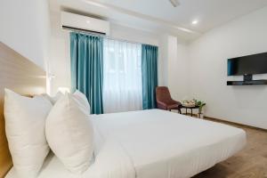 a bedroom with a white bed and a window at RCC Hotels Elite Begumpet in Hyderabad