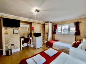 a hotel room with two beds and a table at The Bridge House in Hounslow